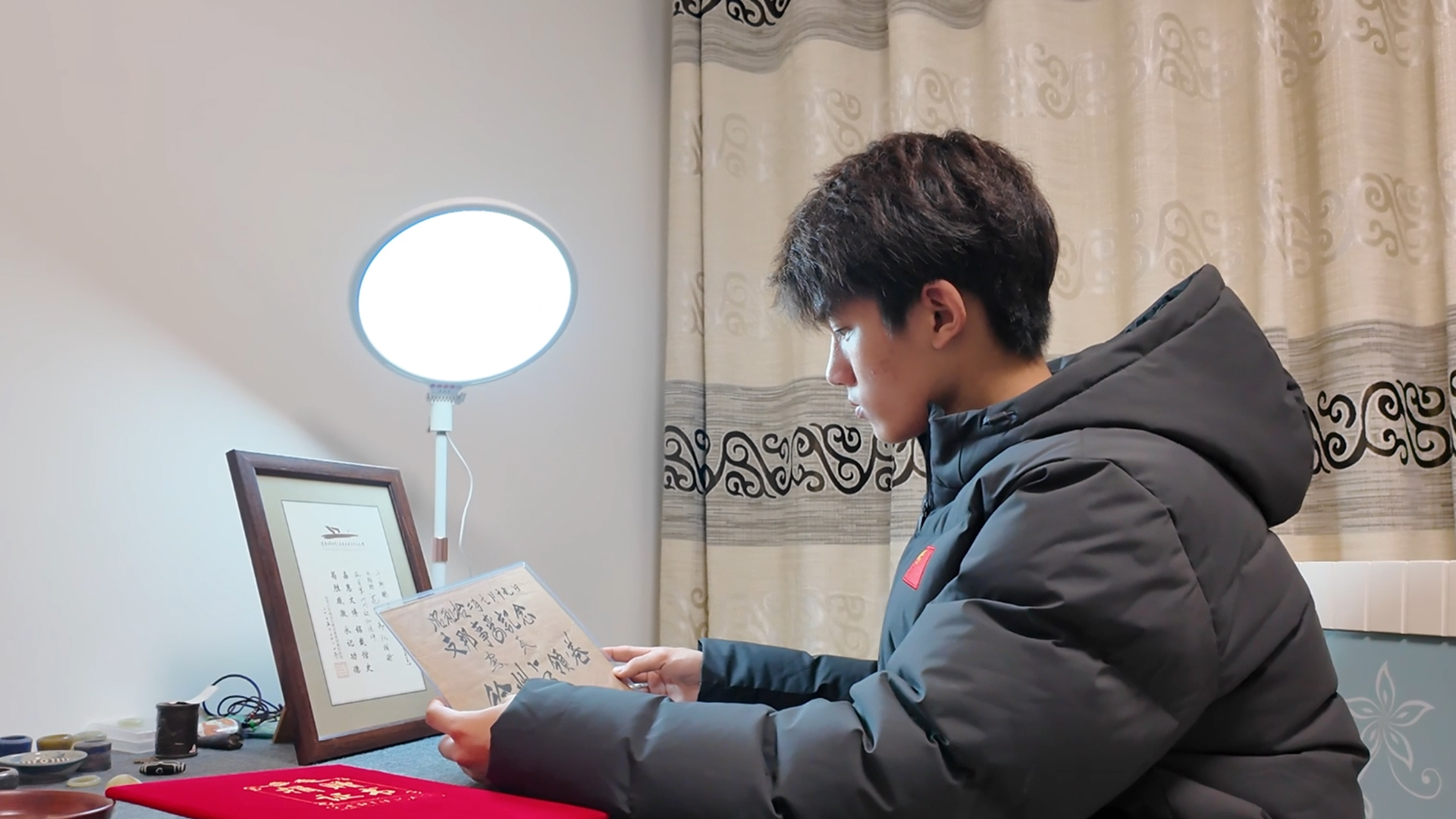 于聍鹏正专注查看写有"支那事变纪念"字样的文献